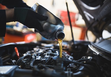 le réparateur de voitures vérifie le niveau d'huile moteur dans l'atelier  automobile, l'inspection des travailleurs de la voiture d'entretien  contrôle les moteurs de véhicules à huile par test de jauge à la
