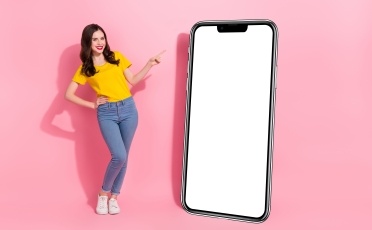 Jeune femme contente avec téléphone géant à côté