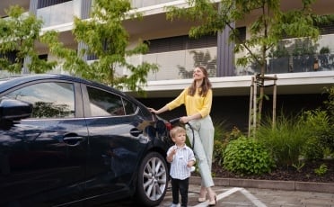 Femme avec un enfant à côté d'une voiture