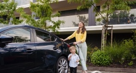 Femme avec un enfant à côté d'une voiture